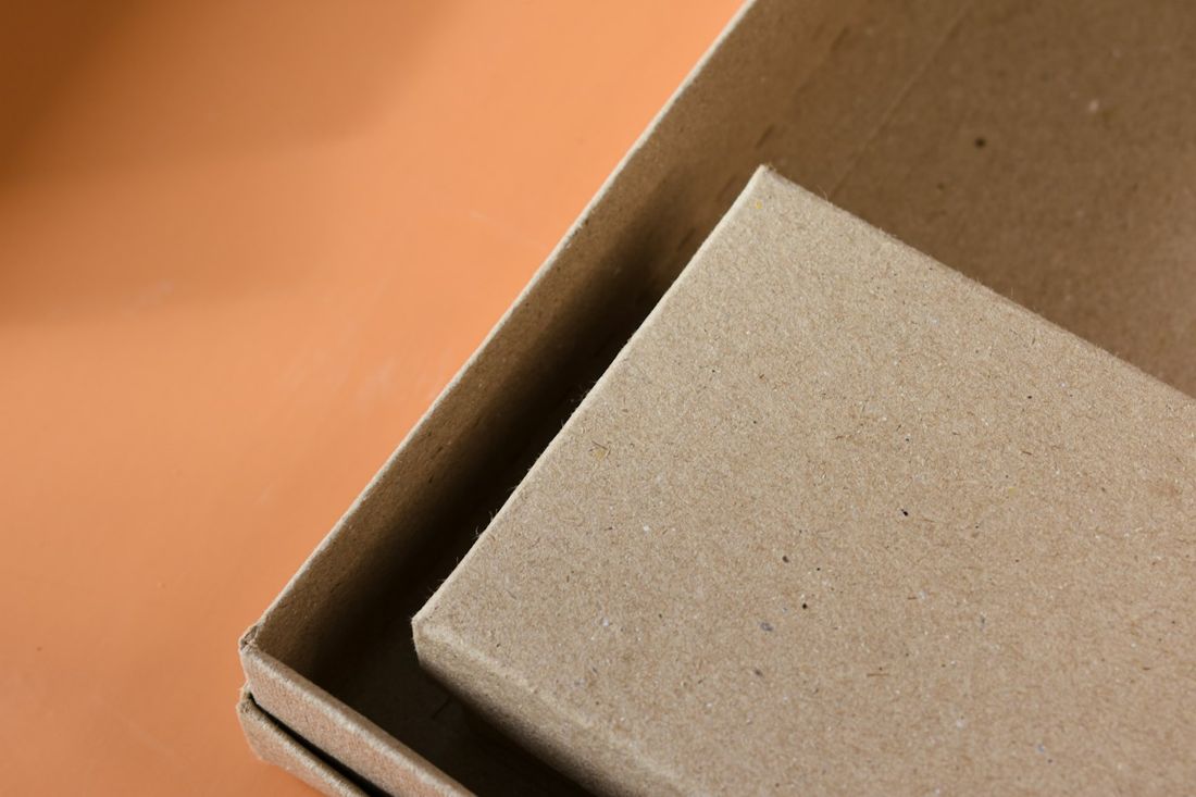 A kraft product box, lid resting on the base